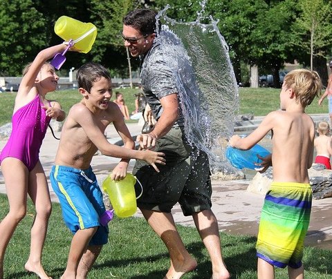 Kinderen vermaken zich in een watergevecht met een man